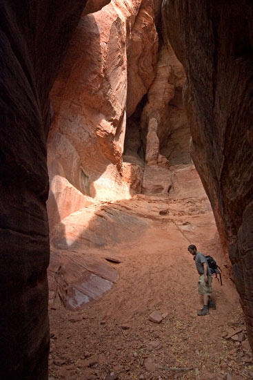 - Hiker Inside a Cave in Cave Knoll, Lower Kolob Plateau, Zion NP -